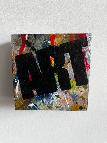 Abstract art piece with black shapes on a textured surface