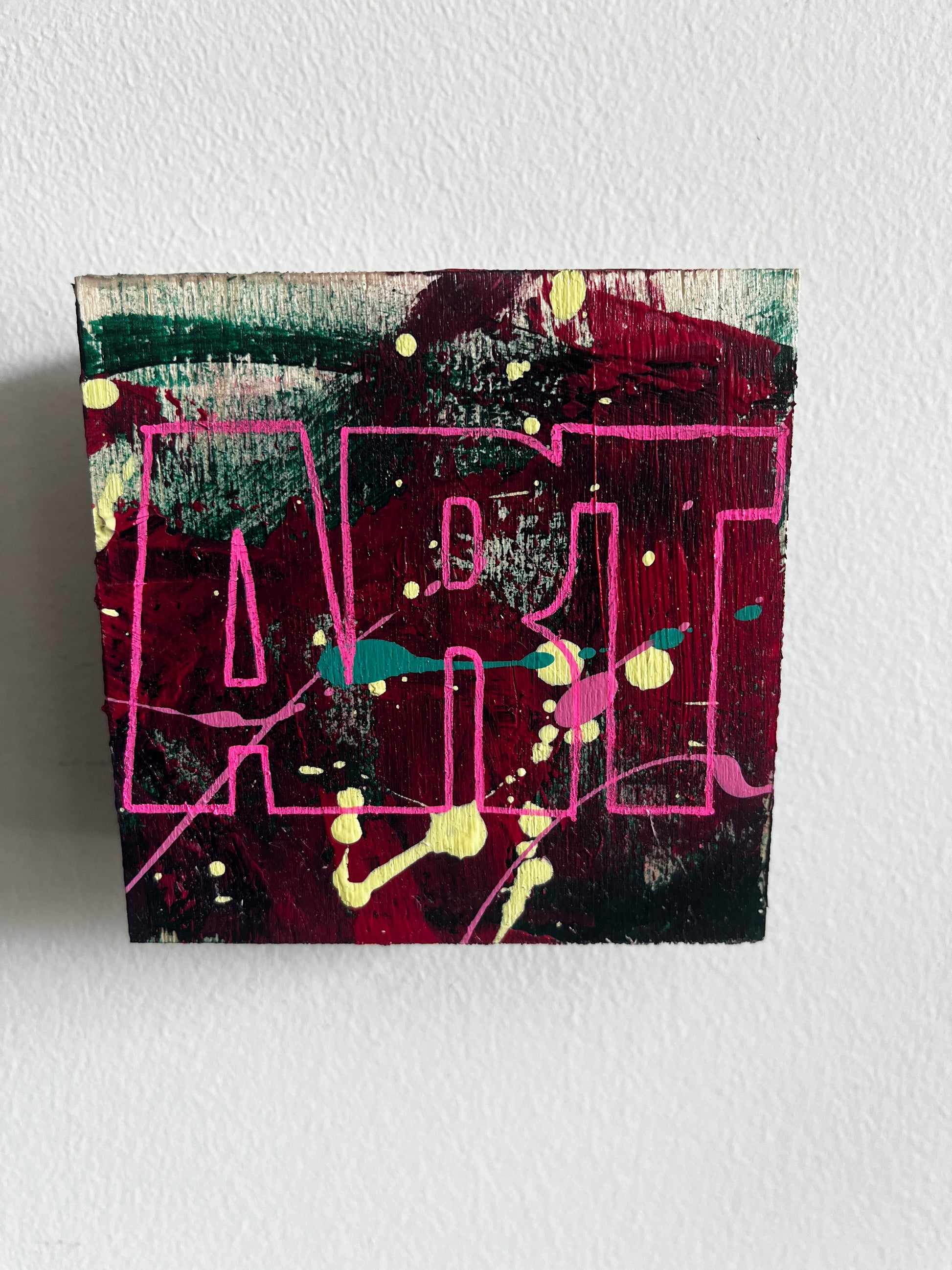 Abstract art piece with pink and green lines on a textured white background