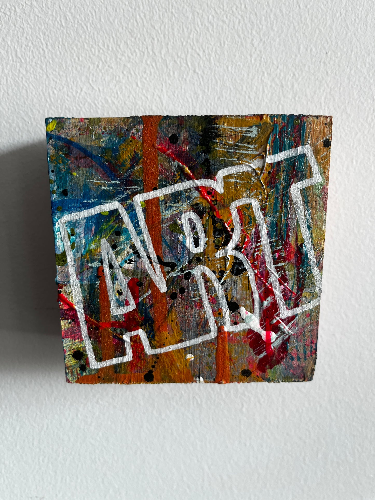 Abstract art piece on a textured white wall