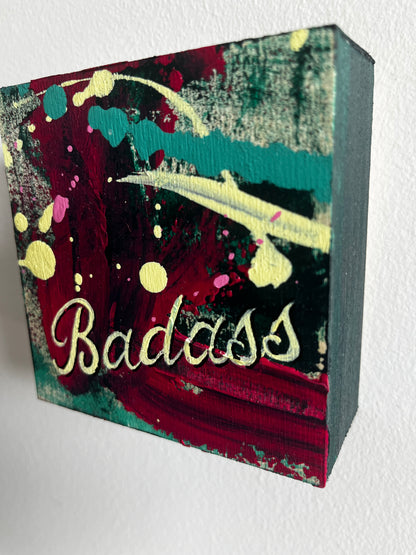 Colorful block with abstract design and the word 'Badass' on a white background