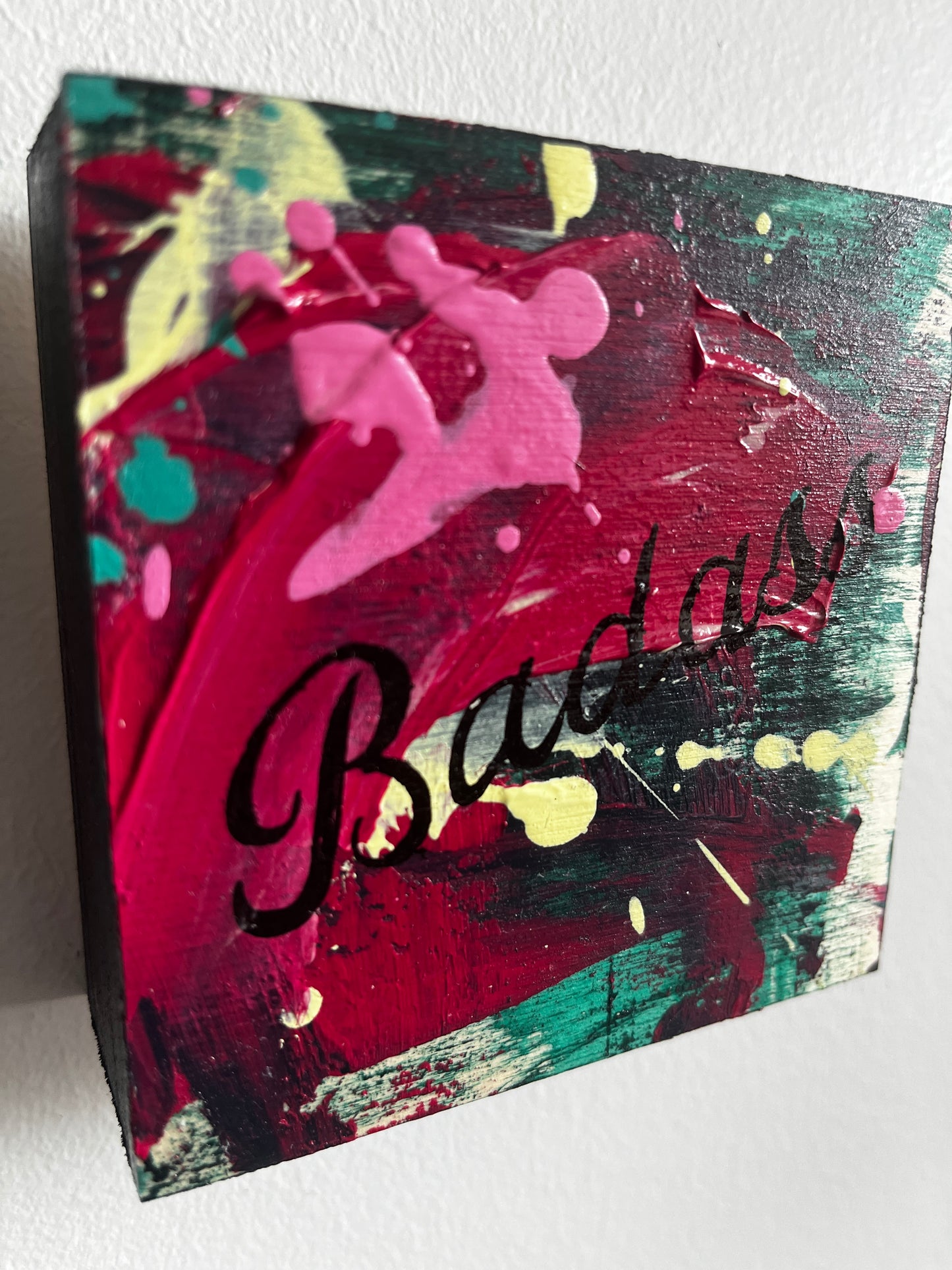 Abstract painting with Black Badass text on a textured surface