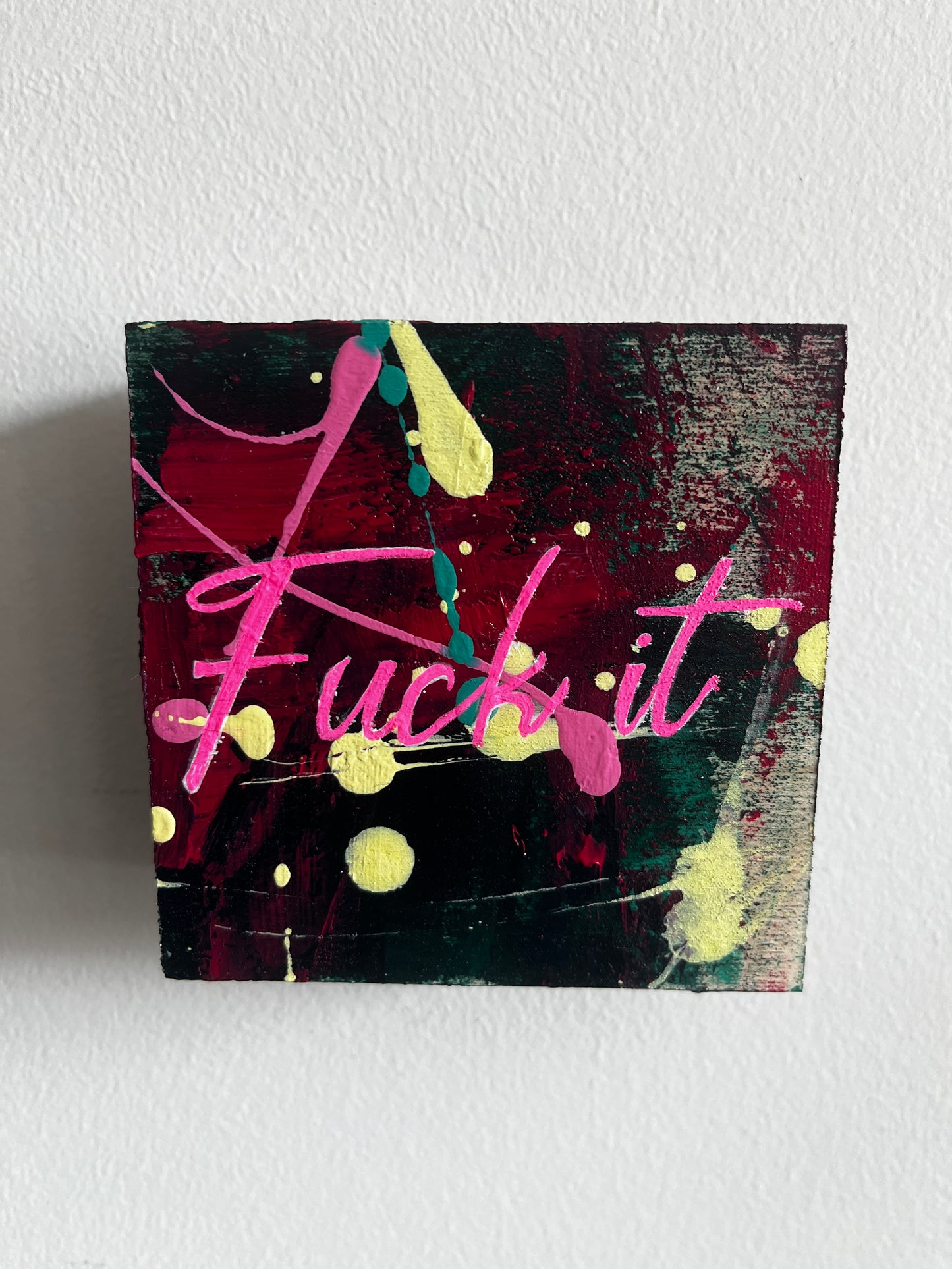 Abstract painting with pink and yellow elements on a textured white wall