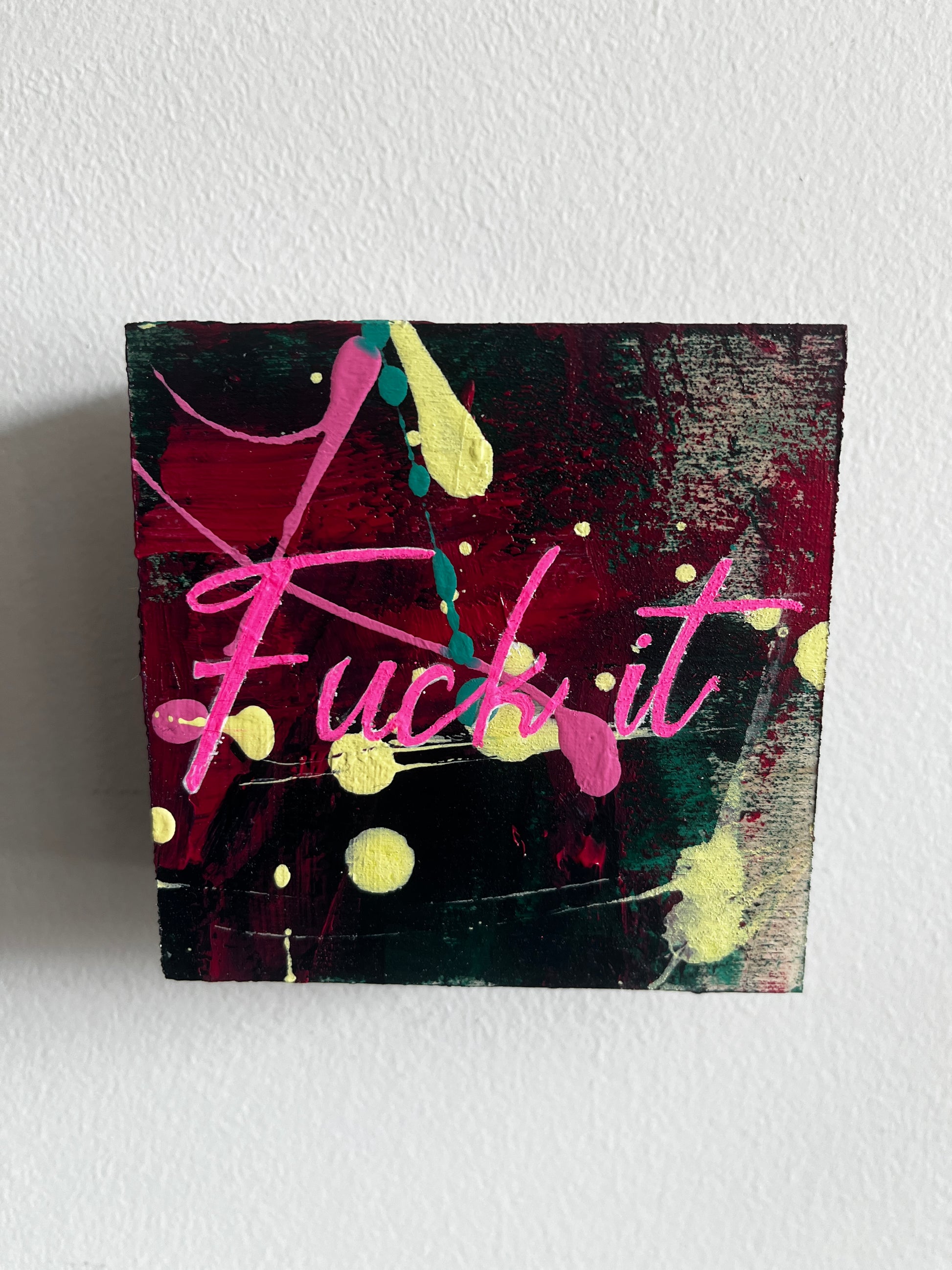 Abstract painting with pink and yellow elements on a textured white wall