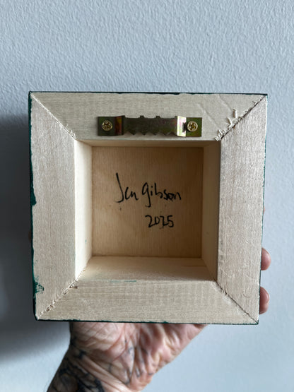 Wooden box with a signature and date on a light blue background