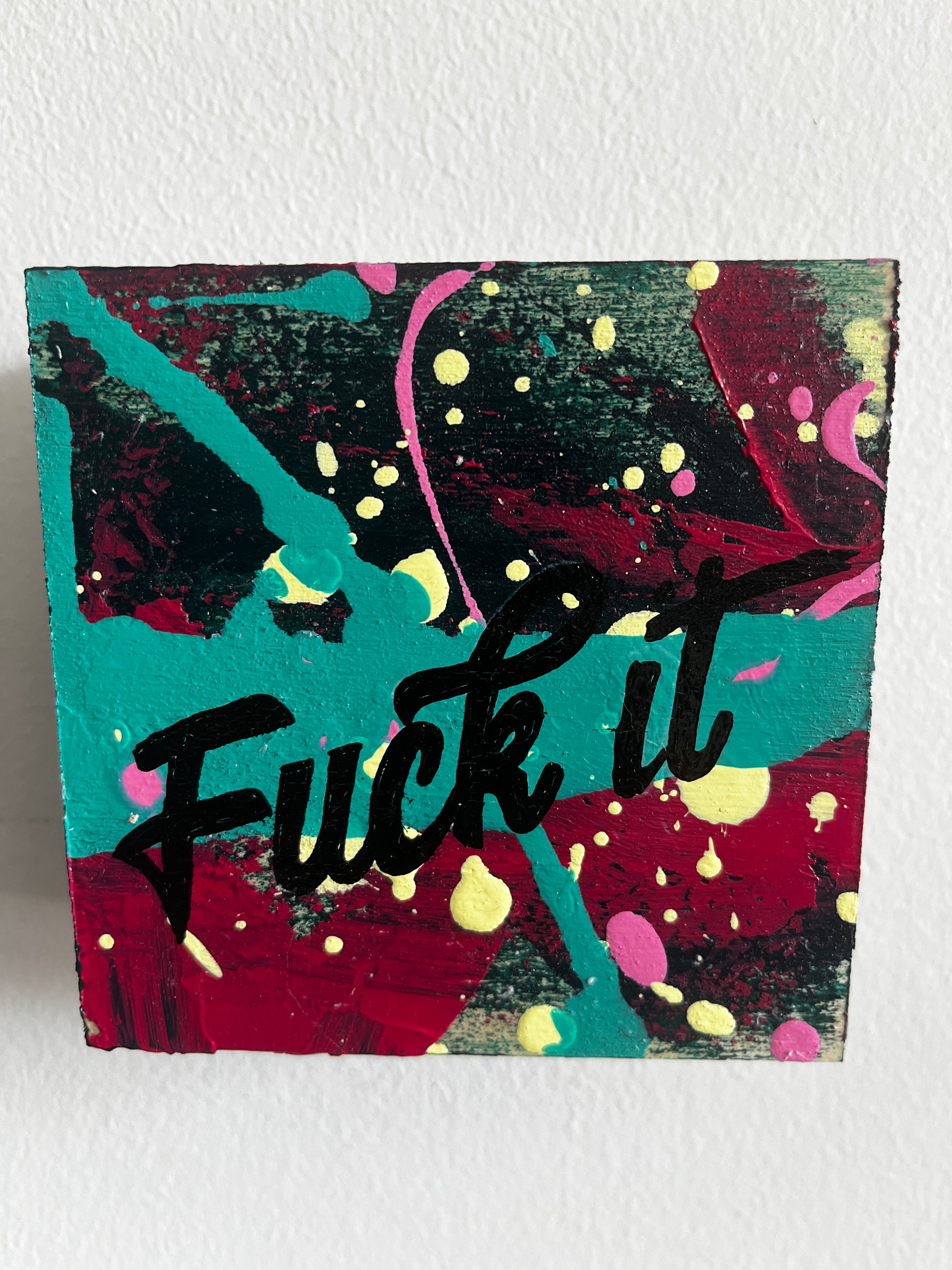 Abstract art piece with colorful splashes and text on a white background