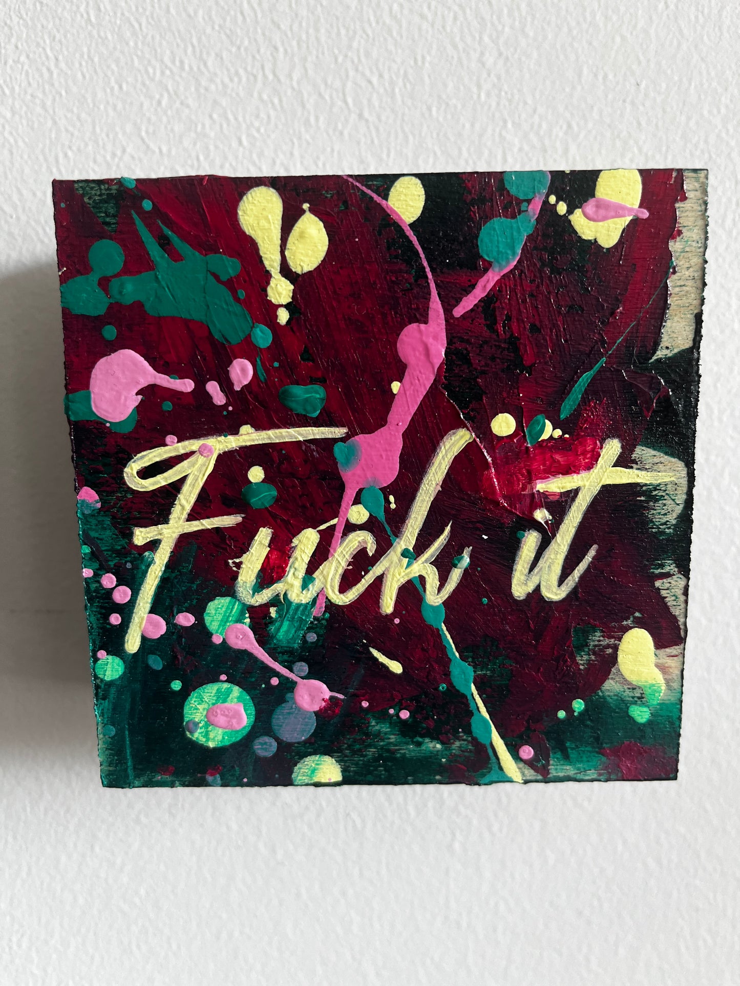 Colorful abstract painting with splashes and Fuck it! text on a white background