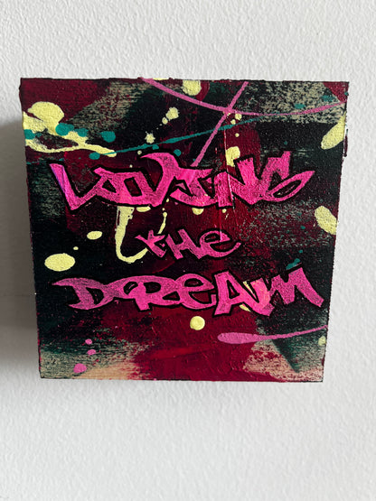 Graffiti-style artwork with pink text on a textured surface