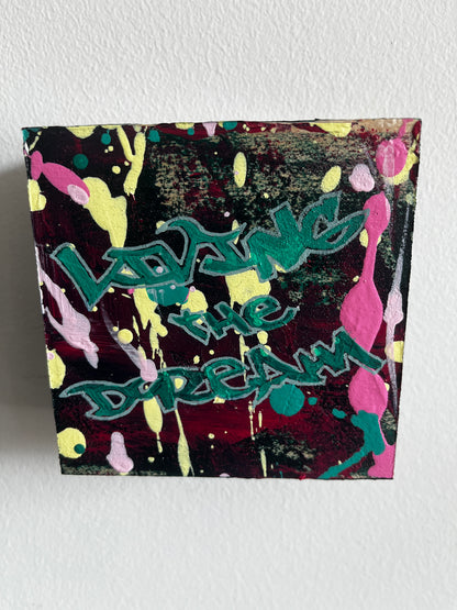 Colorful abstract painting with text on a textured wall
