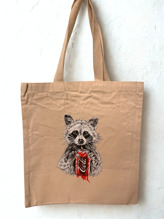 Tote bag with a cute raccoon sipping on a cola