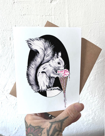 Illustration of a squirrel eating an ice cream cone on a white card held by a person.