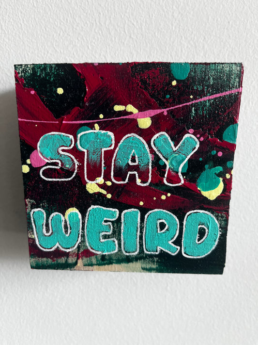 Colourful abstract painting with 'Stay Weird' text on a textured white background