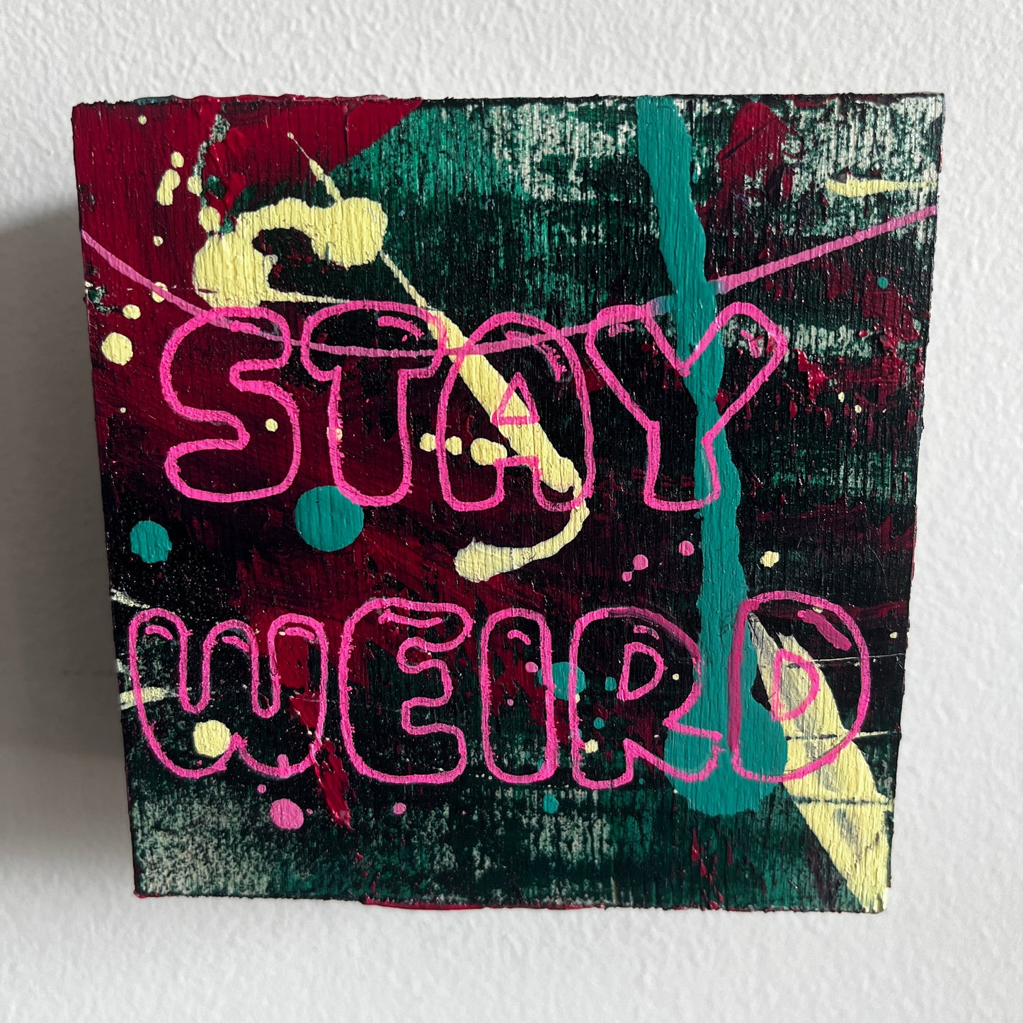 Abstract artwork with colorful text and shapes on a textured white background
