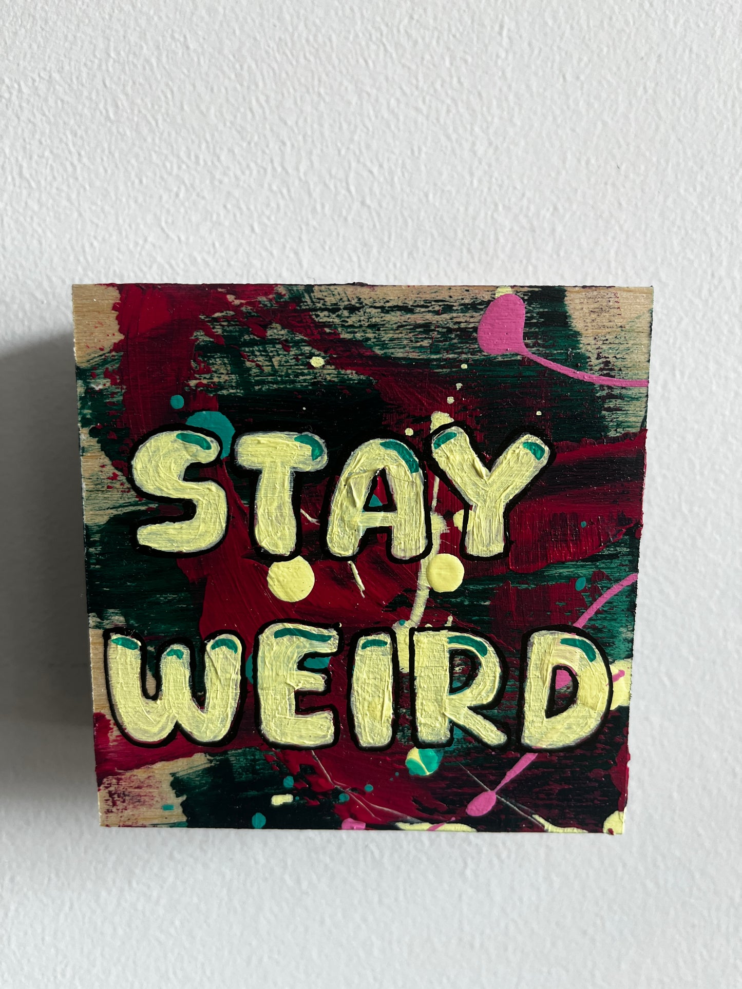 Artistic depiction of 'Stay Weird' with colorful abstract background