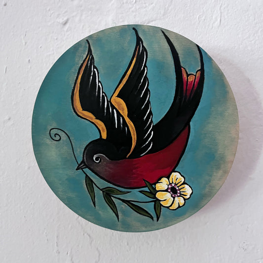 Decorative circular piece with a stylized bird and flower on a textured white background