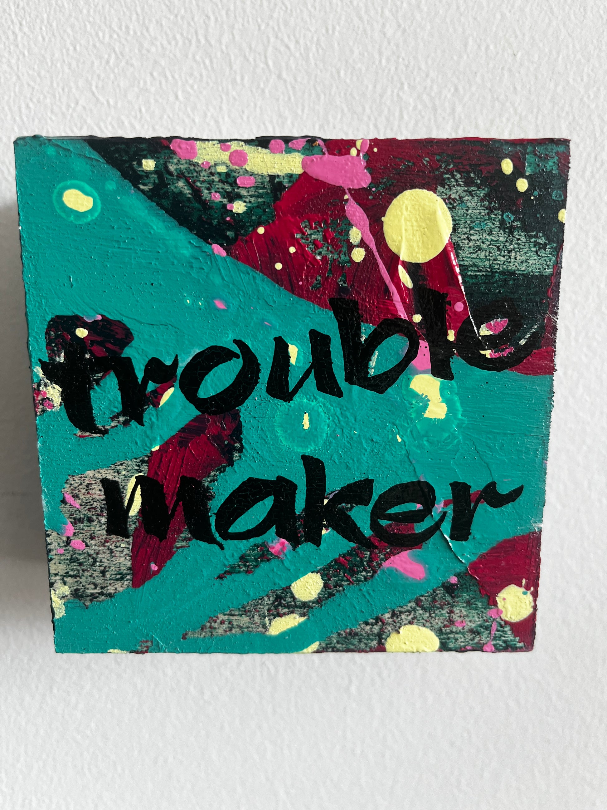 Colorful abstract painting with text on a textured surface