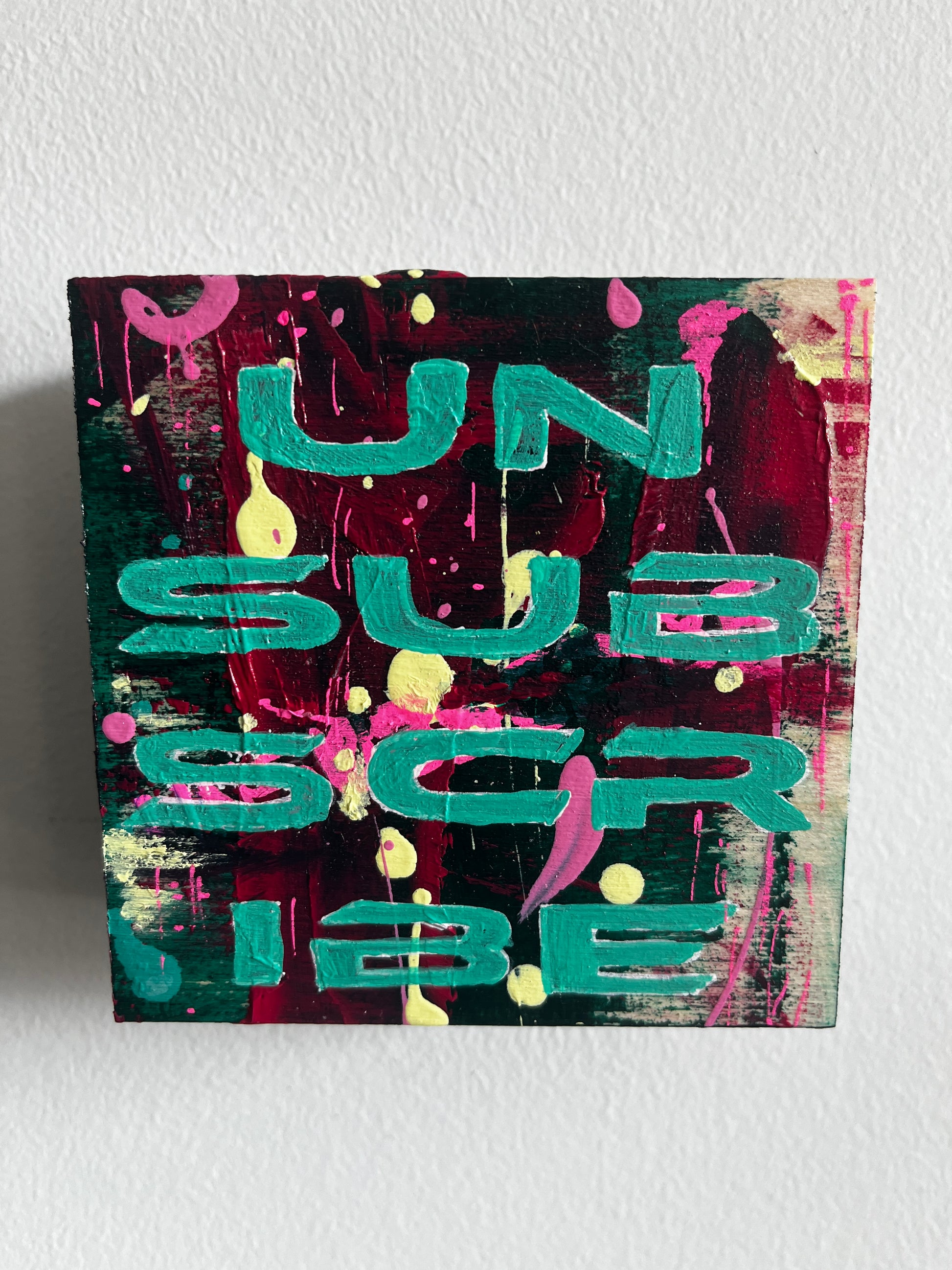 Abstract art piece with colorful letters on a textured white background