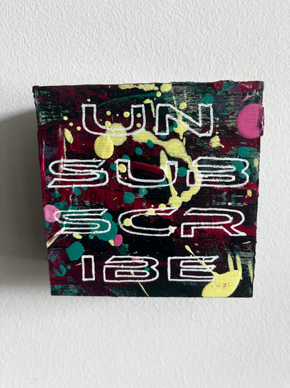 Colorful abstract art piece with text on a white wall