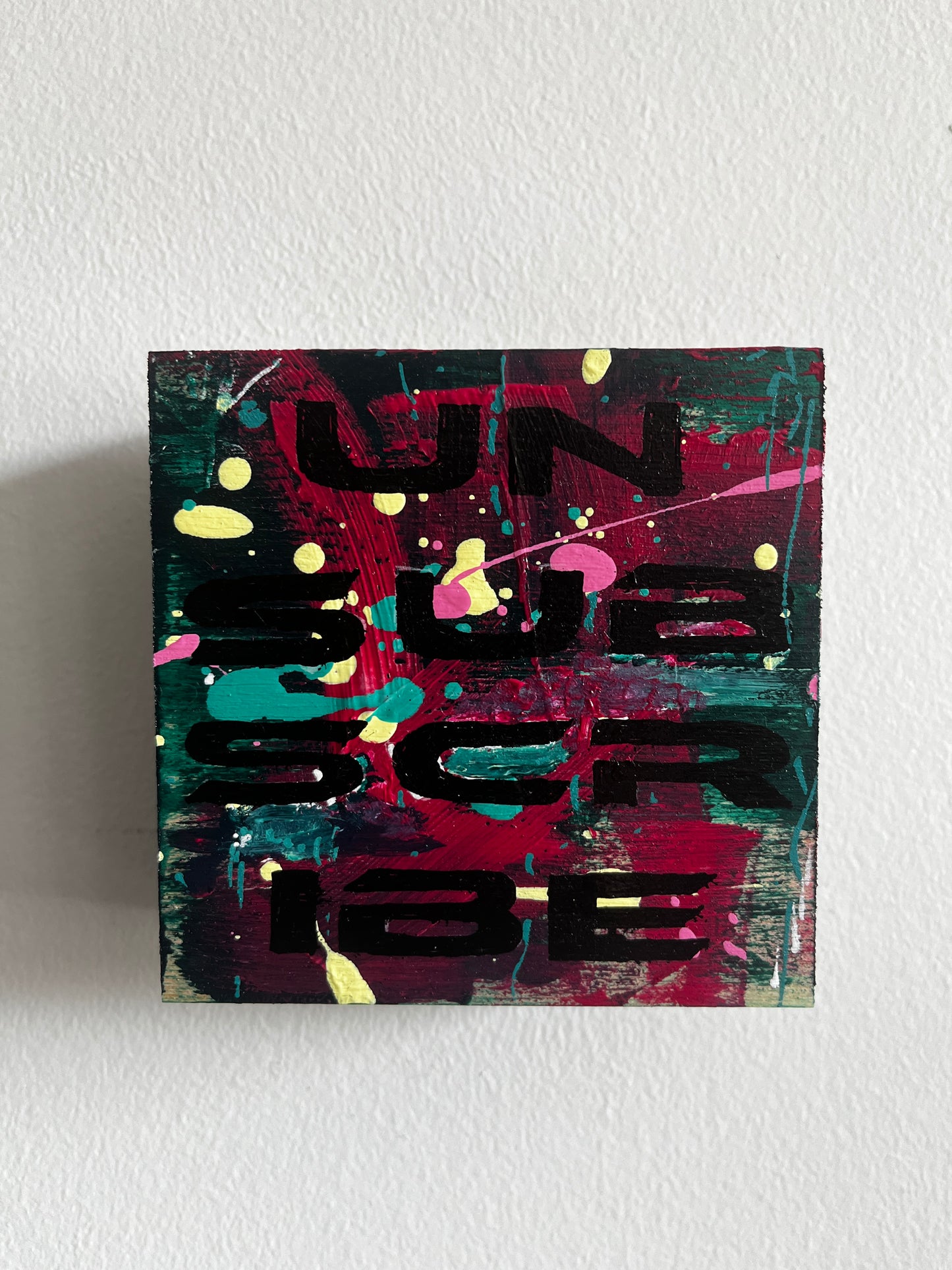 Abstract painting with colorful text on a white wall