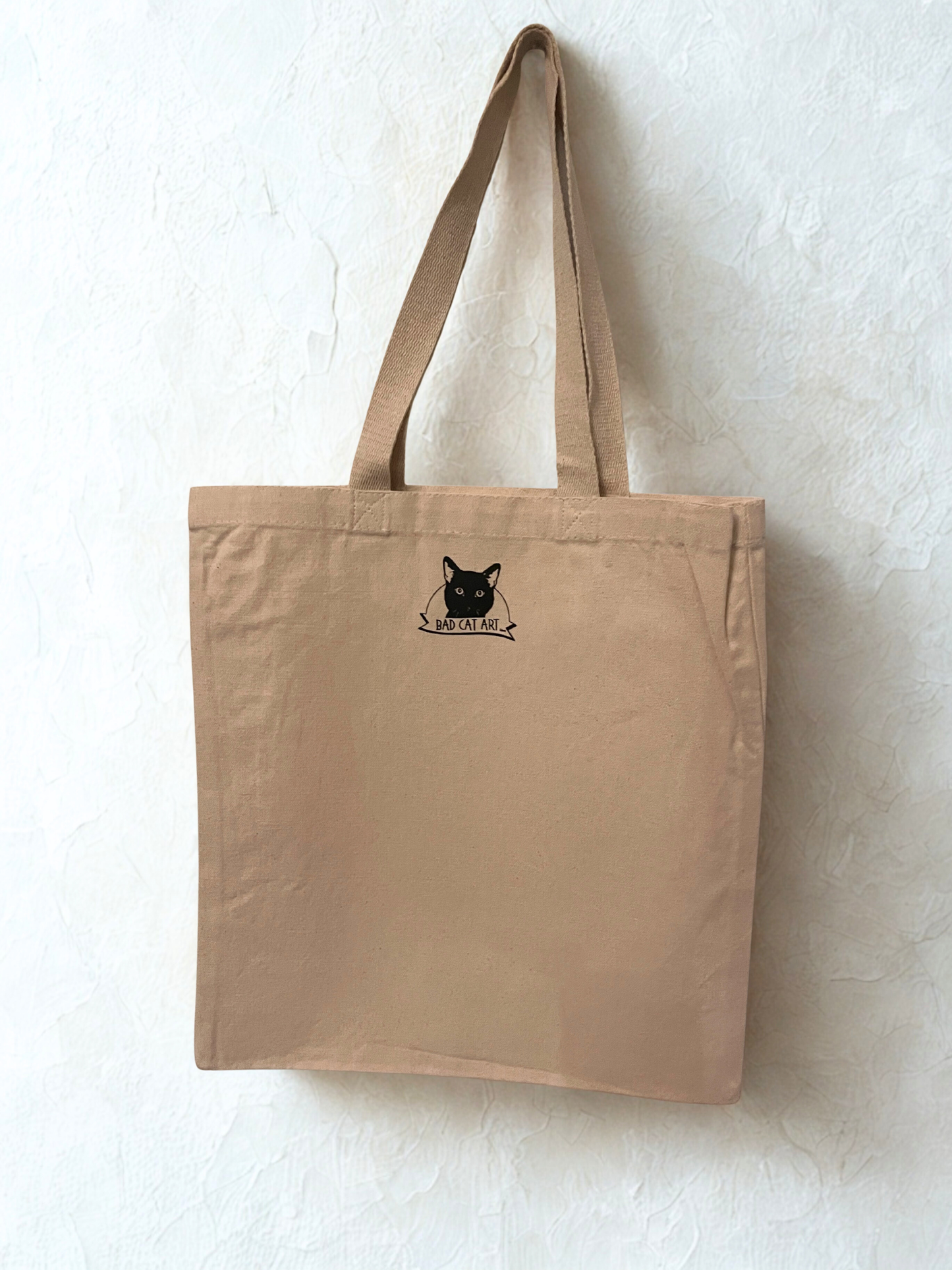 back of big tote bag with logo hanging on white wall