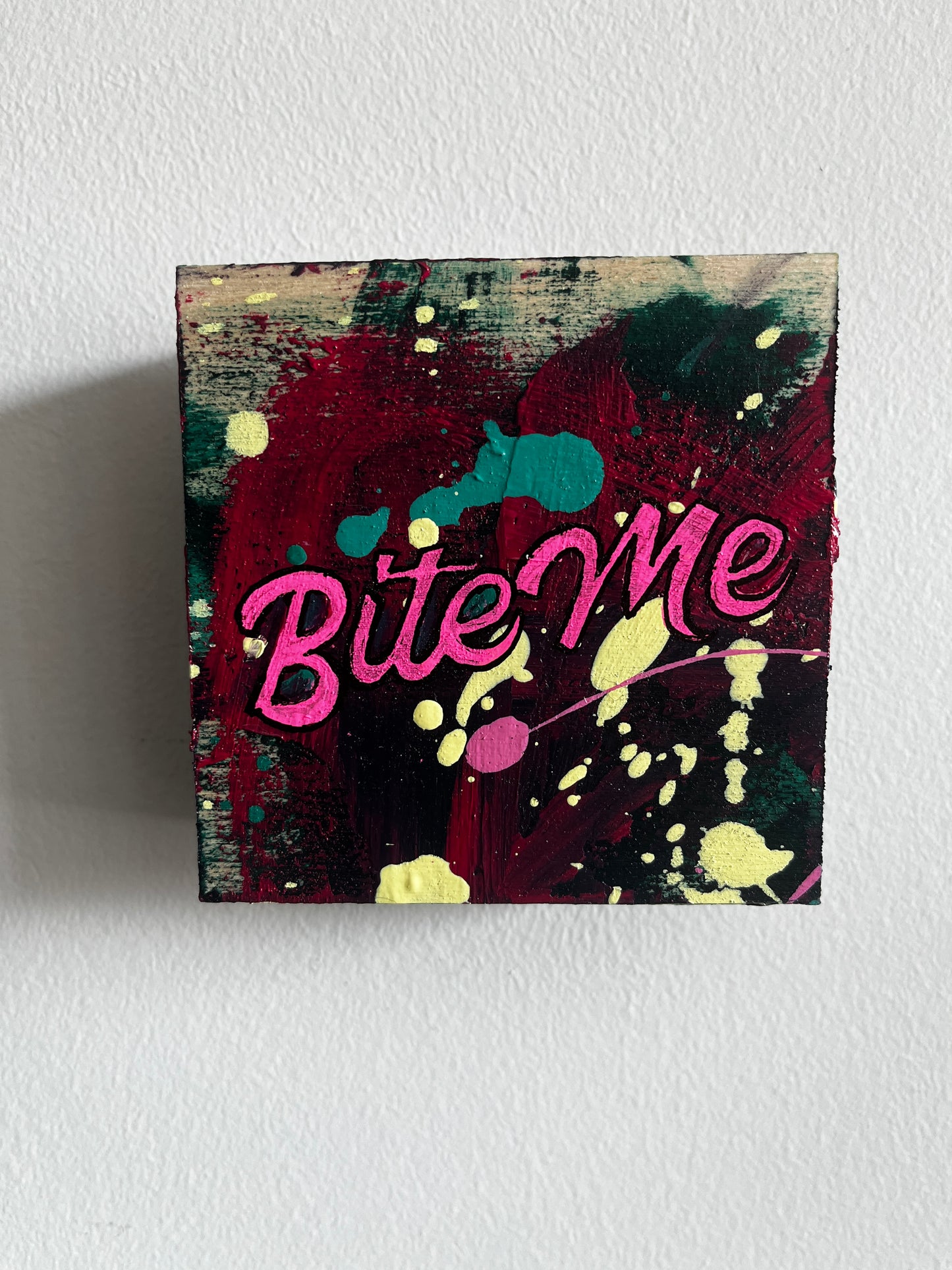 Colorful abstract painting with 'Bite Me' text on a textured white background