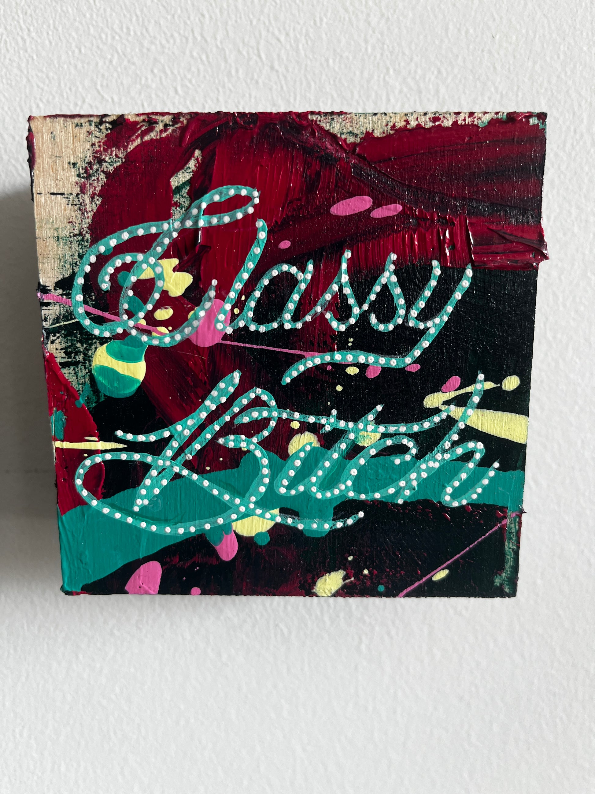 Abstract painting with colorful text on a textured surface