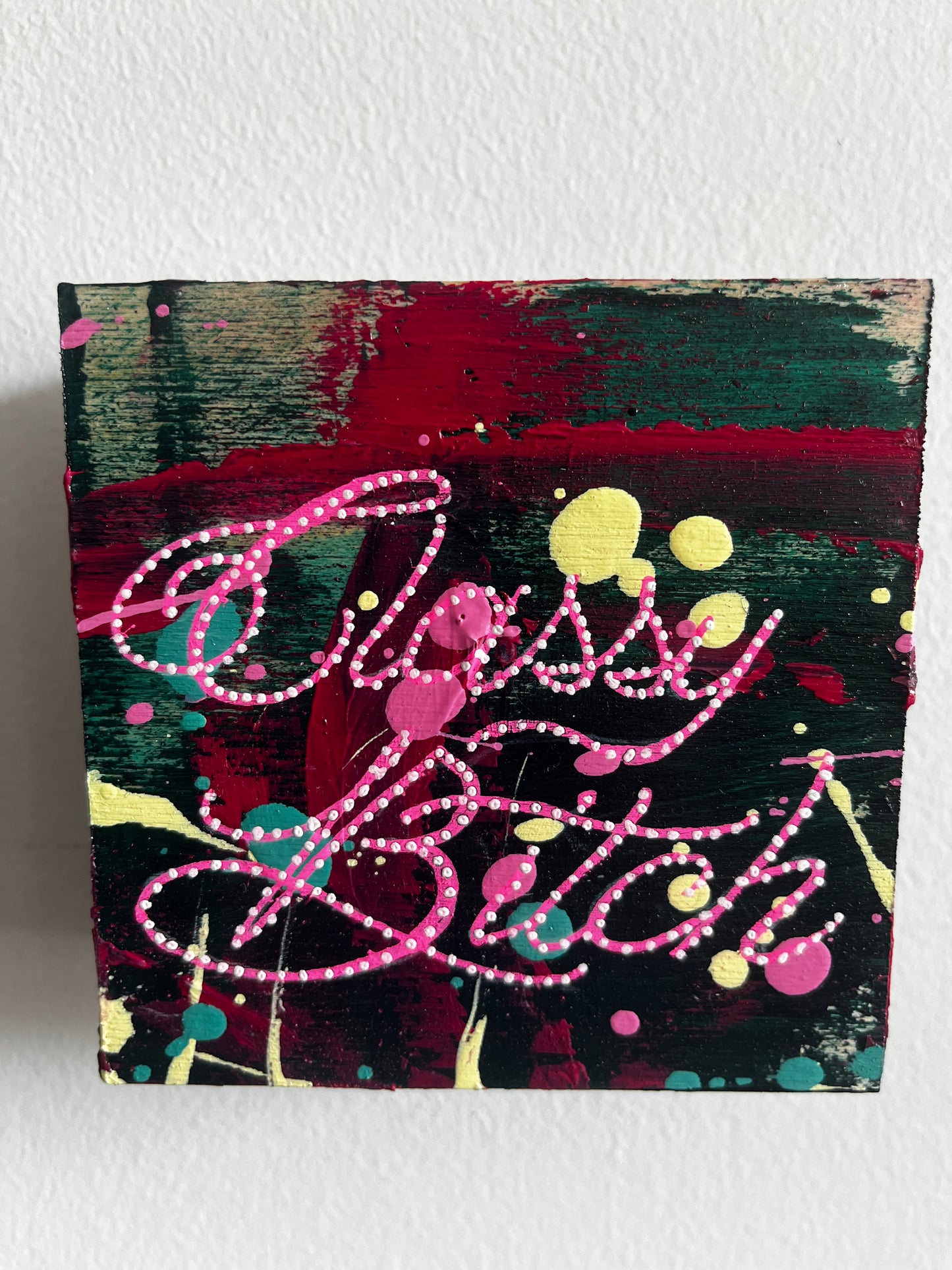 Abstract artwork with pink and yellow elements on a textured surface