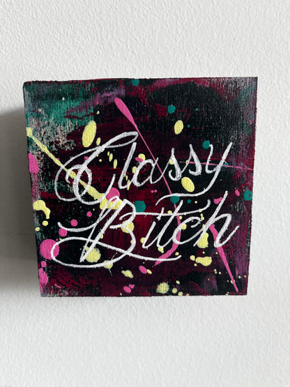 Artistic depiction of 'classy Bitch' with colorful splashes on a textured white background