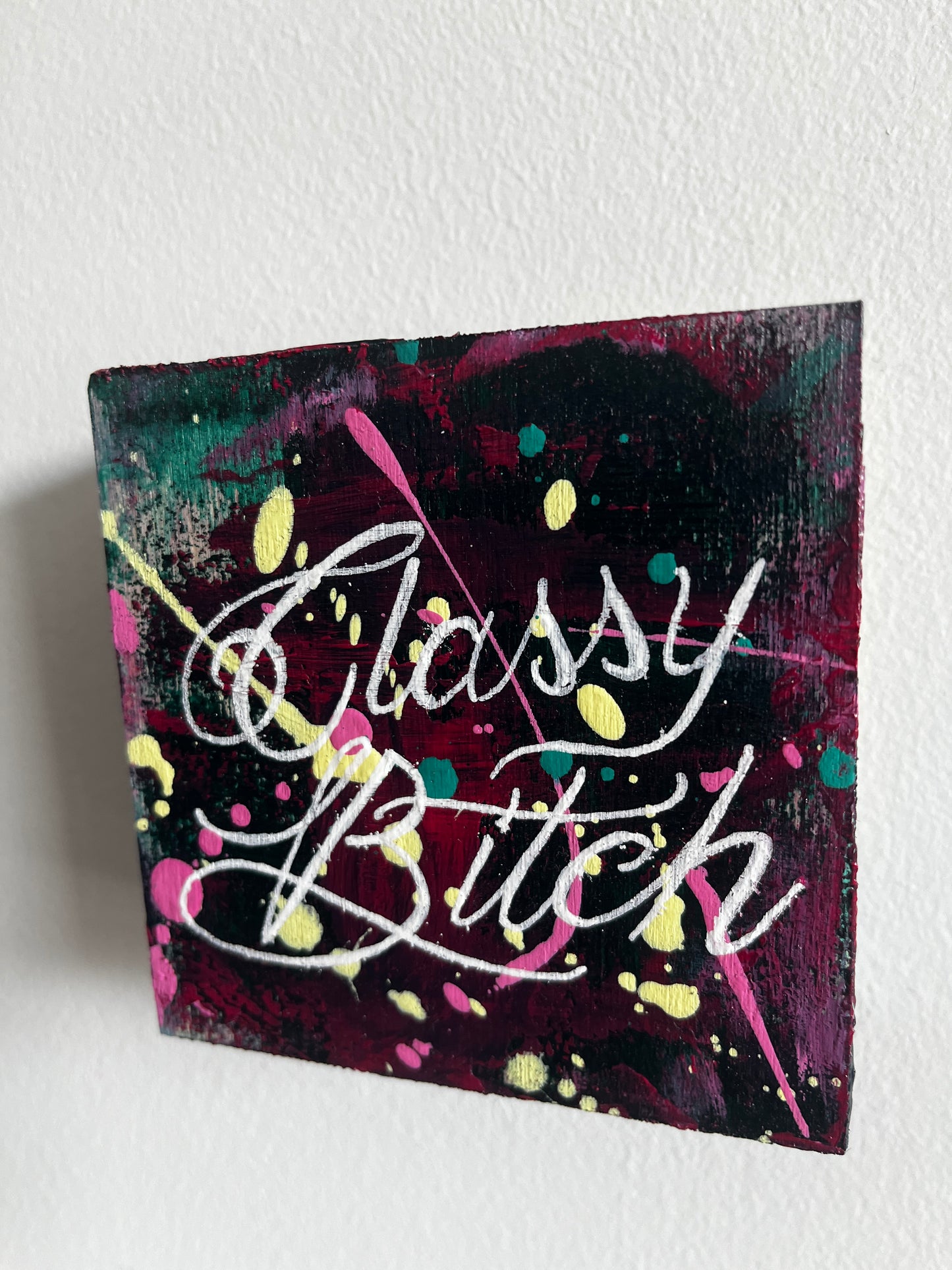 Canvas painting with colorful text and abstract patterns on a white background