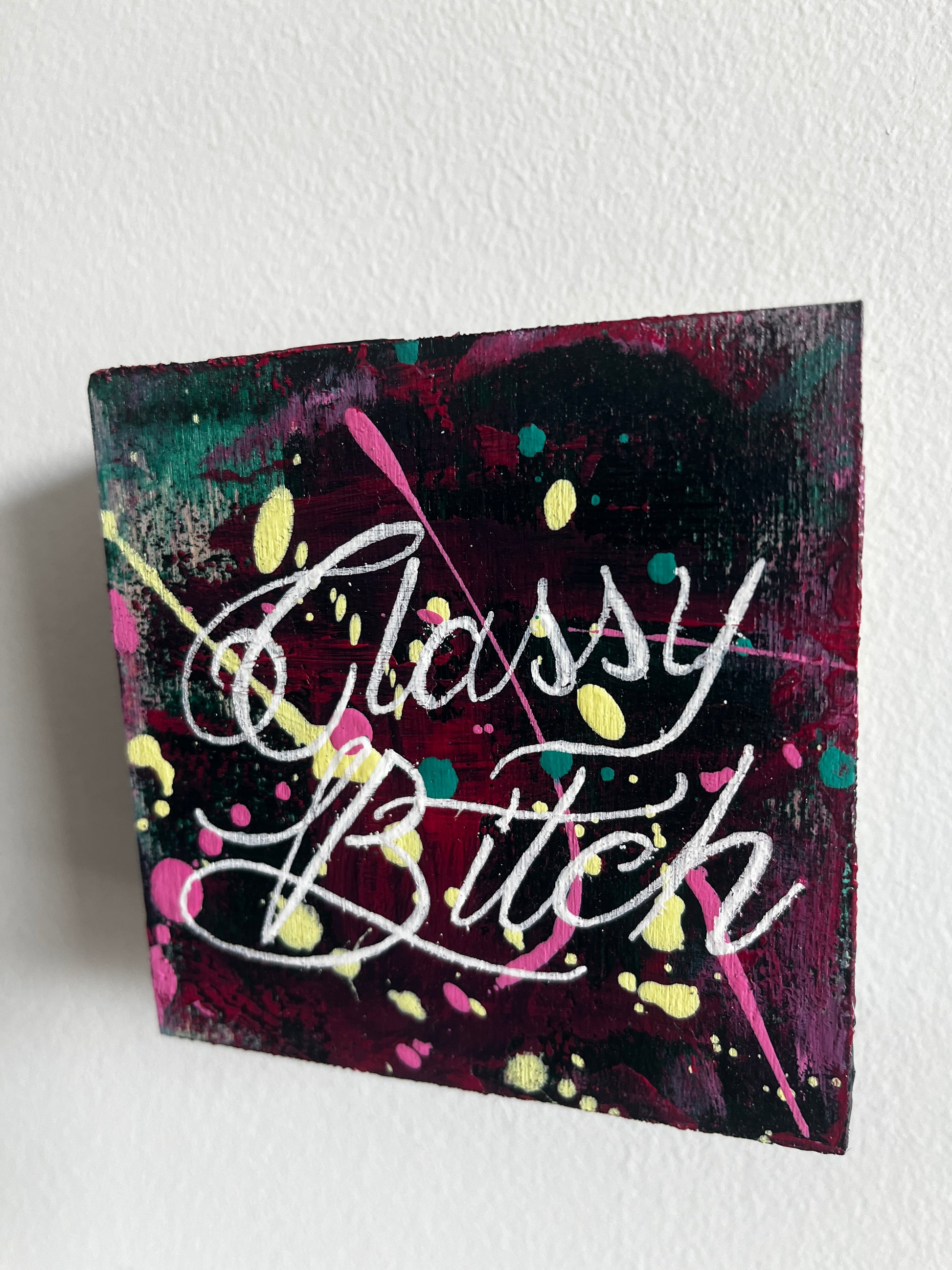 Canvas painting with colorful text and abstract patterns on a white background