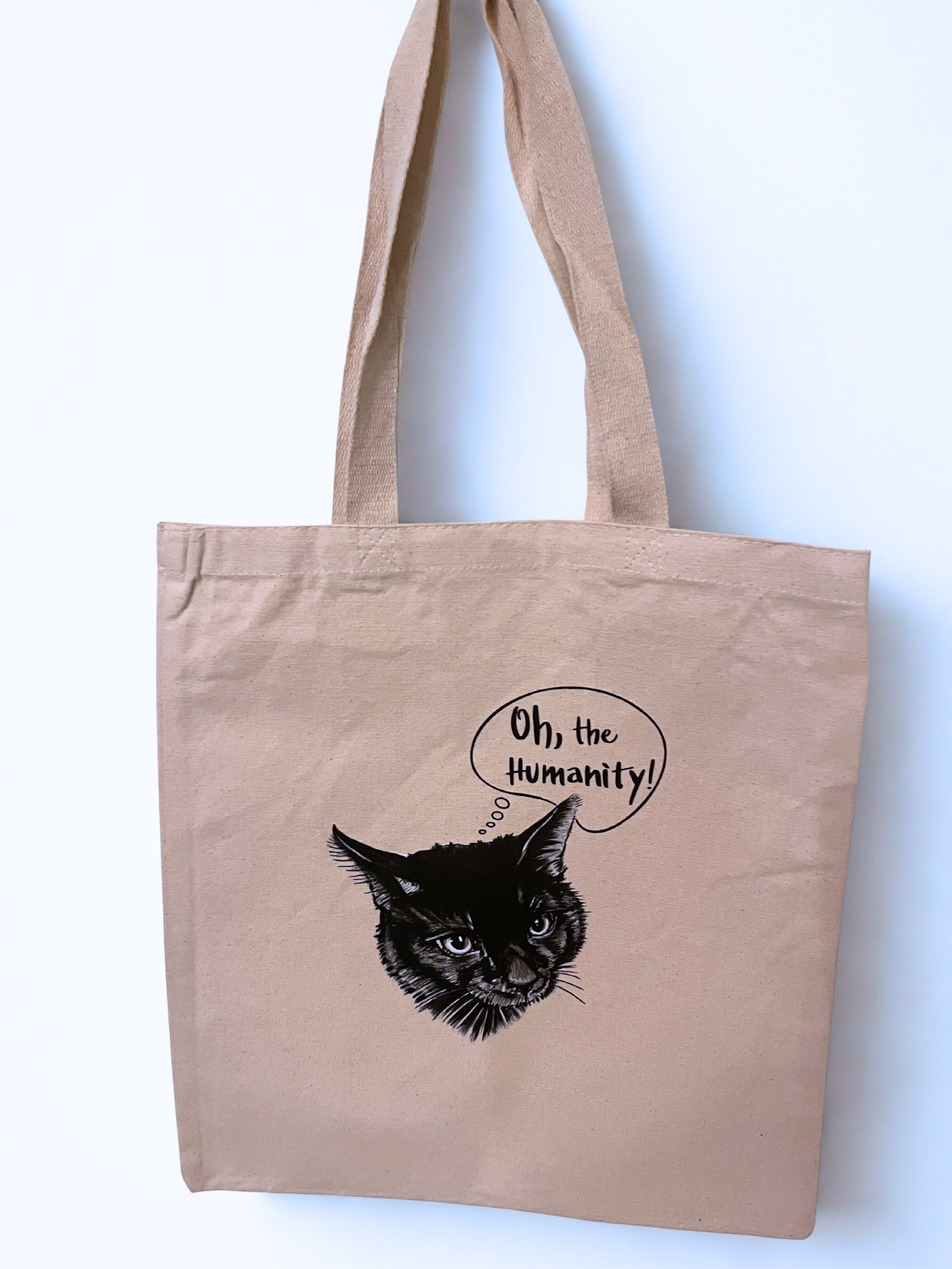 big tote bag hanging on a wall with a black cat