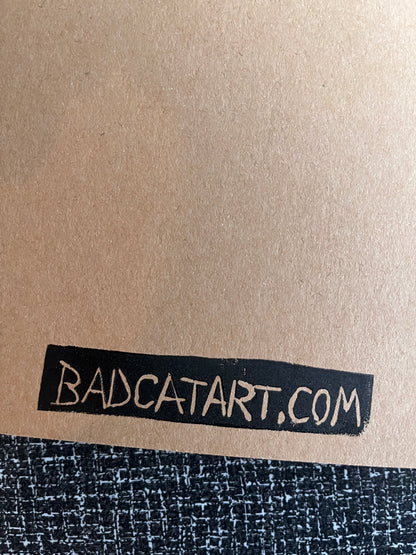 Text 'BADCATART.COM' on a textured surface with a metallic background