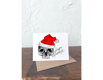 Card with a skull wearing a Santa hat and 'Happy Holidays' text on a white background.