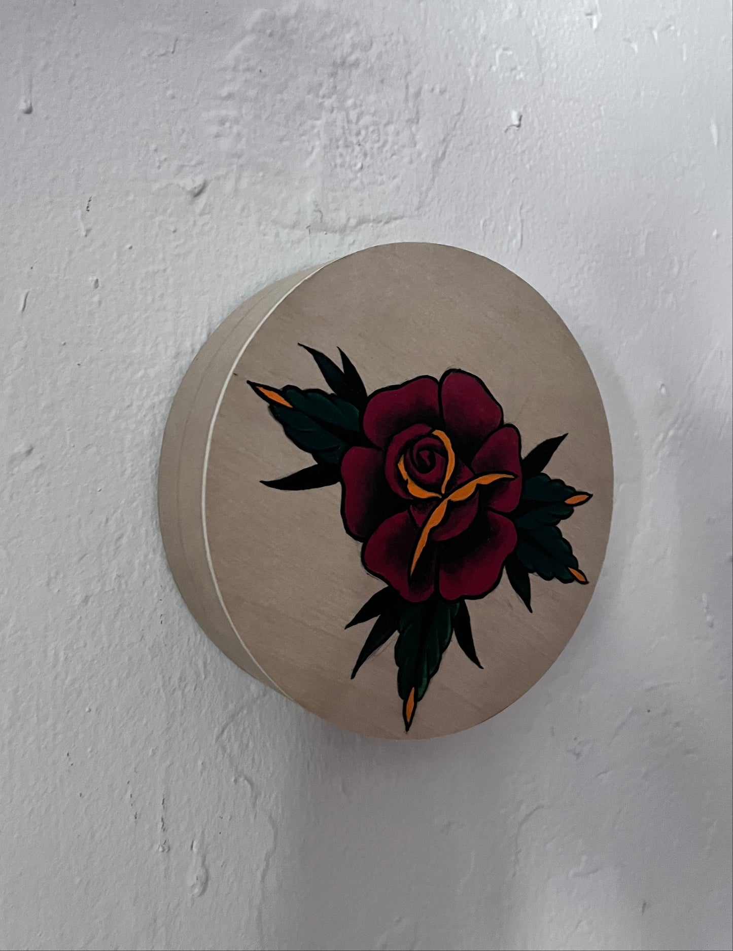 Round beige wood panel with a floral design on a white background