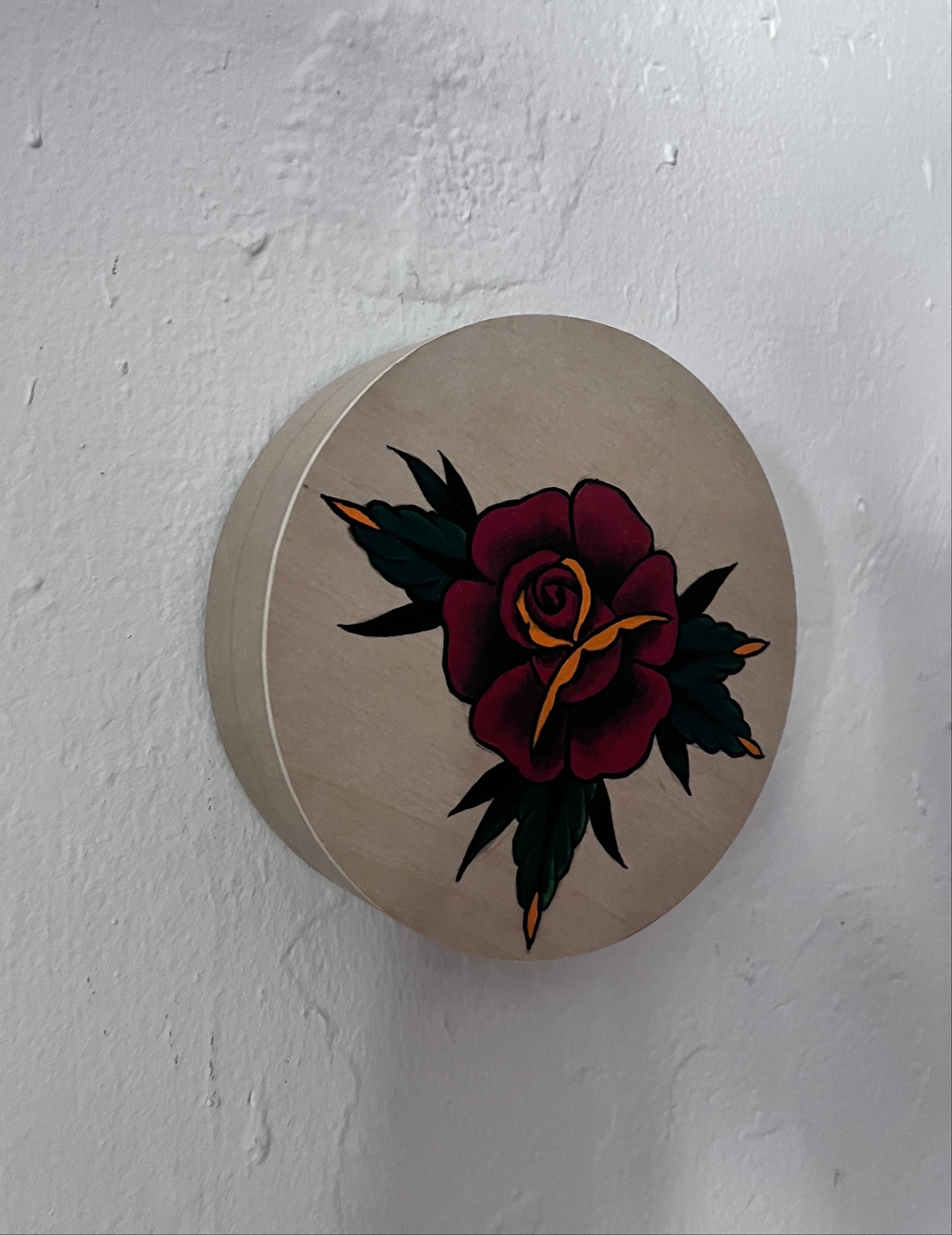 Round beige wood panel with a floral design on a white background
