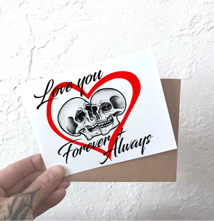 greeting card with two skulls kissing inside a red heart with the caption reading Love you Forever & always