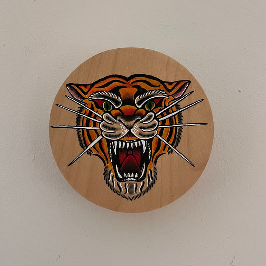 Wooden plaque with a tiger design on a white wall